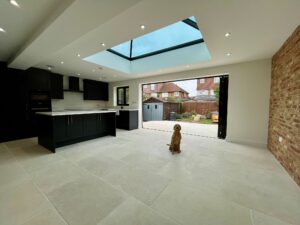 A bright kitchen with a skylight and a dog, featuring a ground floor wrap-around extension by Surrey Developments in Walton on Thames.